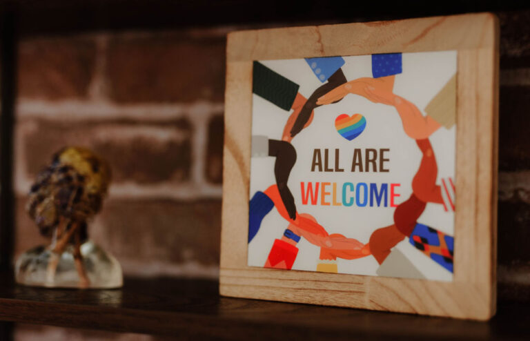 All Are Welcome sign on a shelf in a Hope and Wholeness counseling office