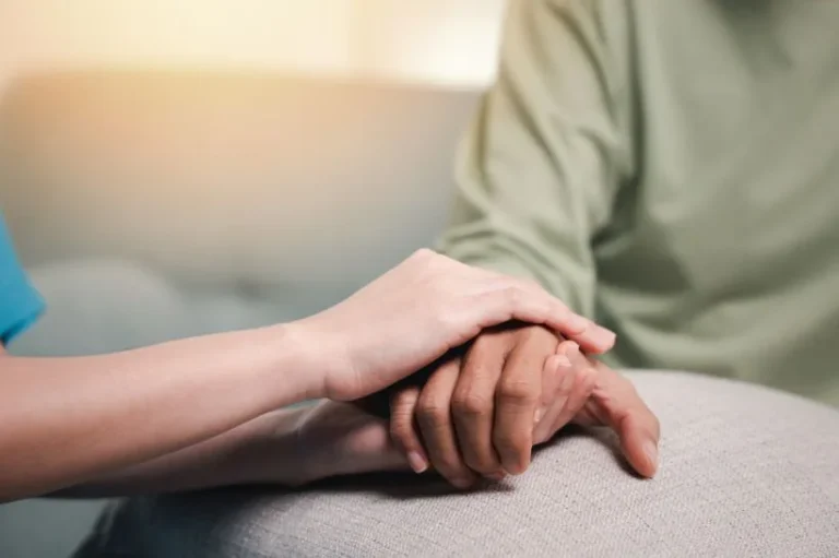 Two people holding hands during a counseling session